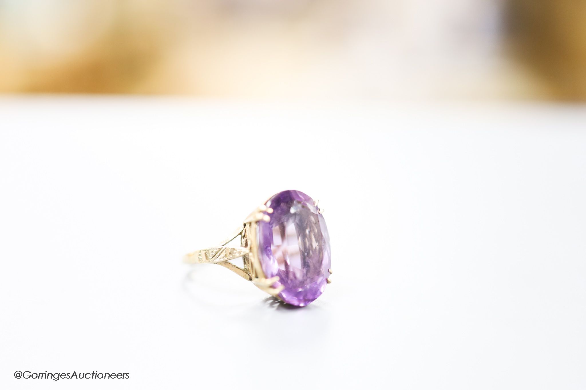 A 9ct gold and oval cut amethyst set dress ring, size H